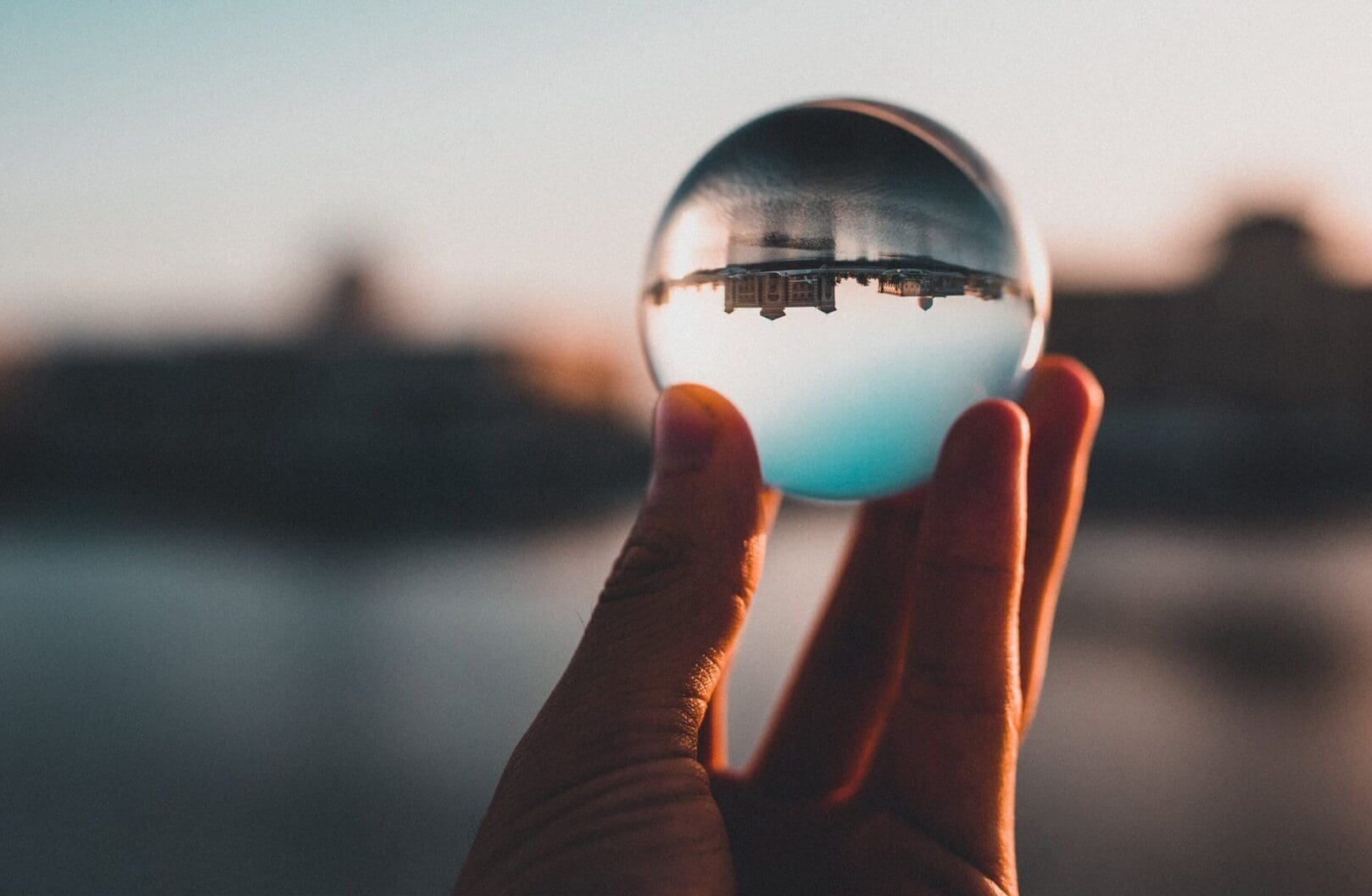A person holding onto a glass ball